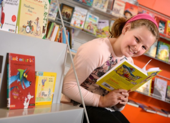 meisje met boek in de bibliotheek op school